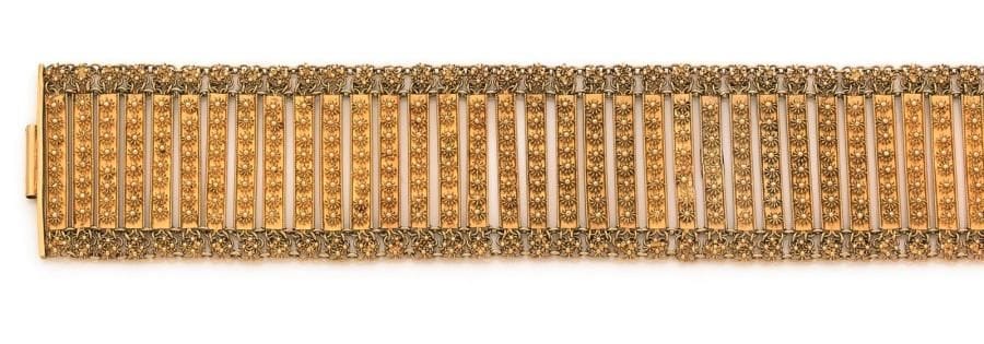Bracelet en or 18K (750 ‰), articulé de maillons ornés de fleurettes filigranées. Dimensions : 3,8 x 18,5 cm environ. 
Poids : 47,8 g