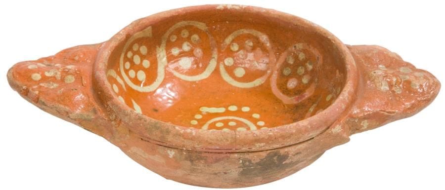 ?Saintonge, XVIIIe siècle - attribuée à la Chapelle-des-pots
Écuelle à oreilles en terre vernissée à décor de cercles et de points à engobe blanc.
Longueur : 22 cm - hauteur : 5 cm
Sur un plat retrouvé dans le lit de la Charente à Port-Berteau figure le même décor. 
Ref : Terres de Saintonge - Jean-Yves Hugoniot - page 165 n°439