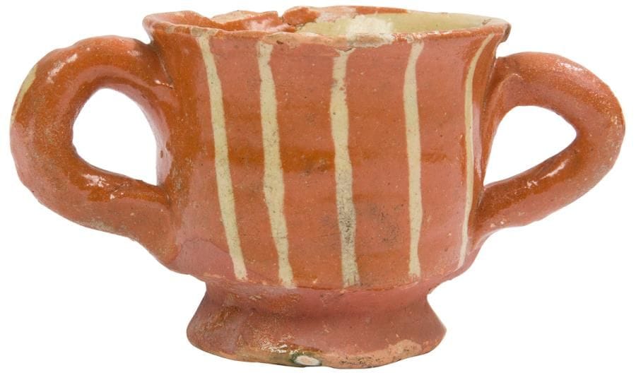?Saintonge, XVIIIe siècle
Tasse à deux anses en boudin, elle repose sur une petite bâte, le corps de forme cylindrique reçoit un décor de bandes verticales de couleur blanche, l’intérieur est recouvert d’un engobe blanc.
Diamètre : 5,7 cm - hauteur : 6 cm