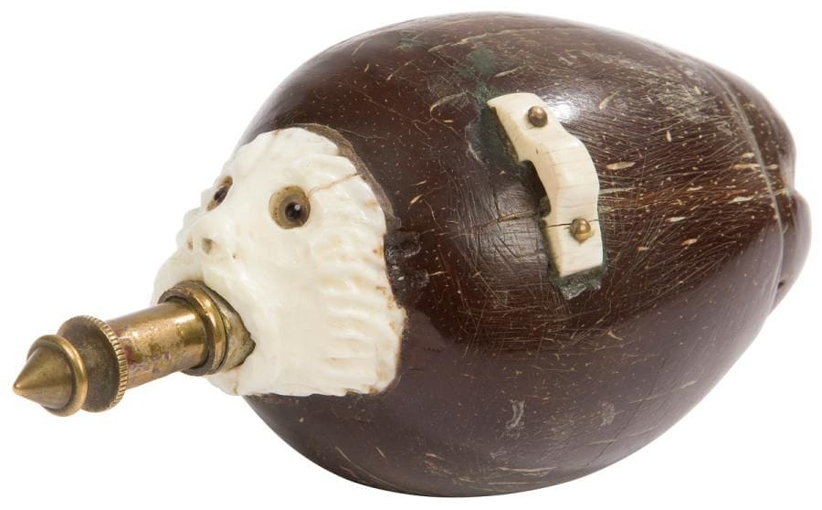 Allemagne, XIXe siècle
Poire à poudre pour la chasse, en noix de coco, os et laiton, taillée et incrustée. 
Longueur : 14 cm - diamètre 7 cm