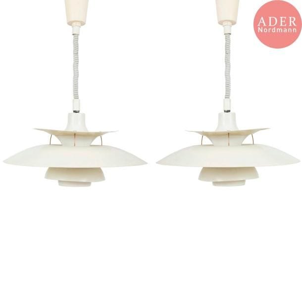 Poul HENNINGSEN (1894-1967) Designer & Louis POULSEN Éditeur
Charlottenborg PH 5, modèle créé en 1926. 
Paire de suspensions, chacune composée de disques incurvés concentriques et de dimensions diverses, en métal laqué blanc, bleu et rouge à l'intérieur. Usures et torsions de certaines coupes en métal. D. 50 cm
