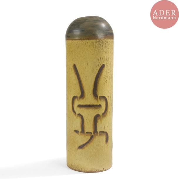 François BOQUEL (1928-2017)
Grand vase obus. Épreuve en céramique à décor abstrait émaillé brun sur fond moutarde. Épaulement et pourtour du col émaillé brun. Monogrammé F.B. et daté (0)3-(19)94 sous la base. H. 57 cm
Né à Nancy le 15 août 1928, François Boquel quitte l’école et sa famille à 16 ans. 

Né à Nancy le 15 août 1928, François Boquel quitte l’école et sa famille à 16 ans. Fasciné par les arts du feu, c’est en parfait autodidacte qu’il s’installe à Vallauris dans les années 1950. Dans le village, il travaillera notamment à l’Atelier Les Archanges aux côtés de Gilbert Valentin. Il nouera également à cette époque une solide amitié avec le peintre André Cottavoz, avec qui il restera longtemps en contact, le céramiste François Raty, mais aussi Jacques Prévert avec lequel il aimait échanger sur l’art.  Il s’installe en Île-de-France dans les années 1960, région qu’il ne quittera plus jusqu’à son décès à Meudon en 2017. Bien qu’éloigné géographiquement du village aux cent potiers, il ne cessera de pratiquer l’art de la céramique, en témoignent les œuvres présentées ci-après.