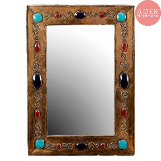 François LEMBO (1930-2013) 
Miroir. Encadrement en céramique émaillée or à décor de volutes et de gros cabochons émaillés bleu, turquoise et rouge. Quelques éclats sur le pourtour. Signé F. LEMBO au revers. 63 x 45 cm

