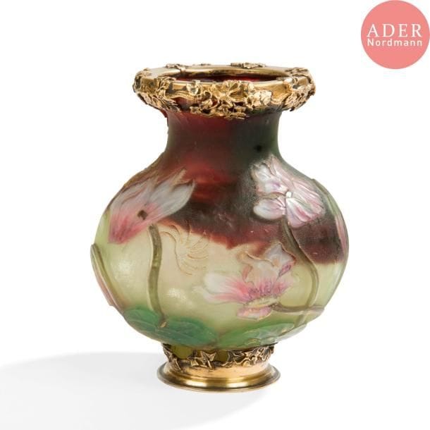BURGUN - SCHVERER & Cie (Verrerie d'Art de Lorraine - Meisenthal) 
Cyclamens 
Vase balustre reposant sur talon et à col évasé ; les pourtours du col et de la base cerclés de montures en vermeil aux motifs floraux. Épreuve en verre multicouche au riche et précieux décor, réalisé aux émaux polychromes intercalaires, profondément dégagé à l'acide et finement ciselé à la roue. Le fond vert présente de larges trainées prune et des parties facettées à la roue. Rehauts à l'or sur les tiges, les fleurs et le pourtour du col. Circa 1895 / 1903. Deux fêlures. La verrerie signée du cachet au chardon : B et S & Cie - Verrerie d'Art de Lorraine, à l'or sous la base, le cerclage de la base porte le poinçon de garantie. H. 13,5 cm

Bibliographie :
Verrerie d'art de Lorraine - Désiré Christian - Philippe Olland, éditions Fatton, Dijon, 2010. Œuvre identique reproduite page 68 (Collection Lillian Nassau LLC, New York).
