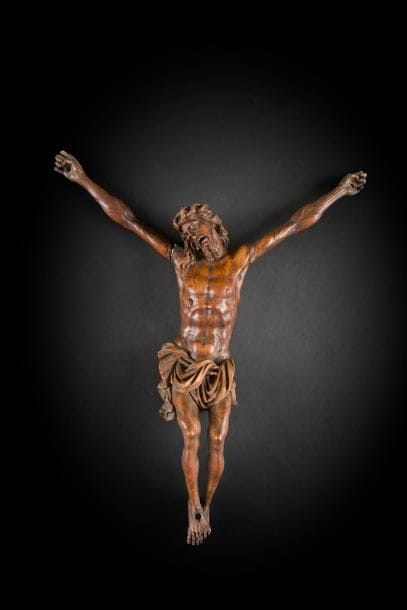 Christ en bois fruitier sculpté, tête inclinée sur l’épaule droite, couronne d’épines torsadée, longue mèche reposant sur une épaule, yeux clos, bouche entrouverte, longue barbe bifide, réseau veineux apparent, caillot de sang à la plaie, périzonium retenu par une cordelette, jambes fléchies et pieds superposés.
Allemagne, XVI / XVIIe siècle
Hauteur : 39 cm
(petits accidents aux pieds et aux mains)
