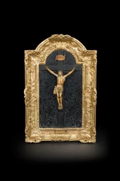 Tableau crucifix avec Christ en ivoire sur fond en bois noirci gravé de rinceaux ; cadre à ressauts en bois sculpté et doré de feuillages et de fleurettes. 
Fin du XVIIe siècle
Hauteur du Christ : 32 cm
Hauteur totale : 71,5 cm - Largeur : 48 cm
(manques dans le bas du cadre, reprises à la dorure)
