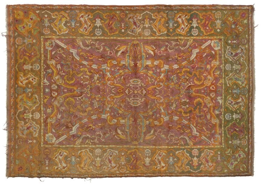 INDE
Tapis à fond vieux rose à grand motifs géométriques entouré d’une large bordure verte également décorée de motifs géométriques multicolores répétitifs.
Usures.
402 x 274 cm