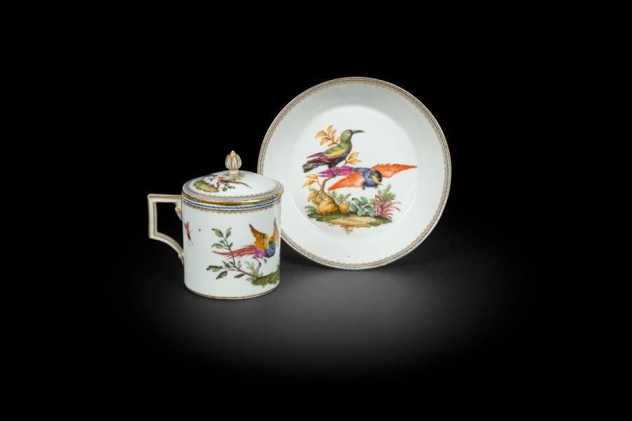 Meissen
Tasse litron couverte et sa soucoupe en porcelaine à décor polychrome d’oiseaux de fantaisie sur une terrasse.
Marquée : épées croisées et étoile en bleu.
Fin du XVIIIe siècle
H : 9,5 cm, D : 14 cm
Quelques usures d’or sur le bord du couvercle