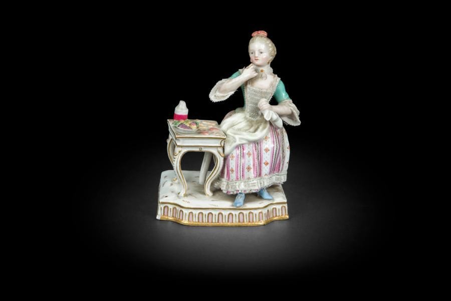 Meissen
Statuette en porcelaine représentant une jeune femme assise près d’une table garnie de patisseries et fruits.
Marquée : épées croisées en bleu.
Fin du XIXe siècle
H : 13 cm