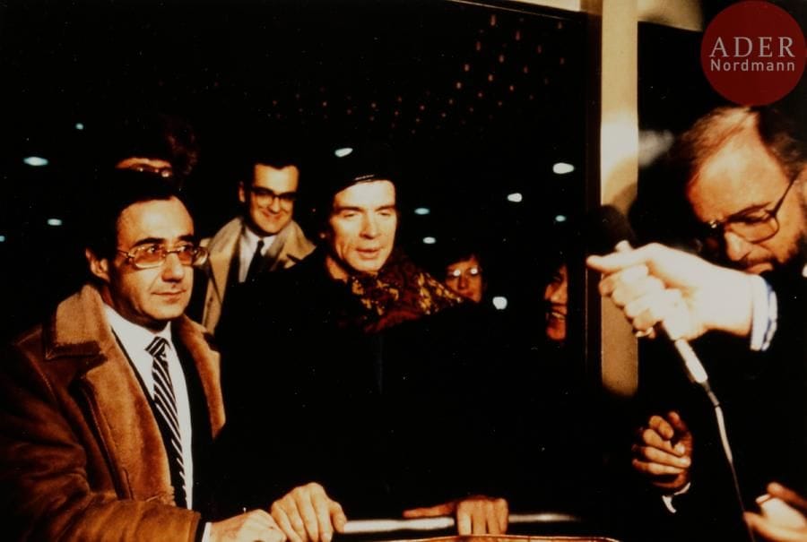 Rudolf NOUREEV (1938 - 1993)
Photographie inédite de Noureev à l’aéroport de Moscou en 1987 accueilli par Georges Matcheret, conseiller de l’ambassade de France.
Tirage couleur.
9,5 x 14,2 cm

 R. Noureev était considéré par les autorités soviétiques comme un transfuge depuis sa déféction en 1961. Il n’a reçu l’autorisation qu’en 1987 de se rendre à Oufa, avec un visa de 72 heures, au chevet de sa mère malade. G. Matcheret lui a servi de protection diplomatique lors de son passage à Moscou, Noureev craignant un coup bas des soviétiques.

Рудольф НУРЕЕВ (1938 - 1993)
Неизданная фотография встречи Нуреева Жоржем Мачере в аэропорту в Москве в 1987.
Жорж Мачере в то время был советником посольства Франции в СССР.
Цветная фотография.
9,5 х 14,2 см
После «прыжка в свободу» 1961 года Р. Нуреев считался изменником. На родину Нуреев смог приехать только в 1987 г., чтобы навестить умирающую мать в Уфе и то с краткосрочной визой. Ж. Мачере служил ему дипломатическим охранником в Москве; Нуреев серьёзно опасался тогда за свою свободу.