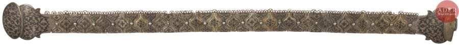 Ceinture caucasienne en argent niellé. Fin XIXe et début XXe siècles.
Cette ceinture comprend 39 éléments enfilés sur une courroie (remplacée) avec une boucle en deux parties. Certains éléments plus anciens sont dorés sur la face avant.
Poinçons : 84, au moins 22 éléments après 1908 de la direction du contrôle du Caucase et du contrôleur de Bakou, avec un poinçon d’orfèvre incomplet mais comportant un « О », 7 éléments une partie de la combinaison du poinçon de Moscou, de la date 1879, avec un maître essayeur dont les initiales se terminent par un « Б » (non identifié), 6 éléments sans poinçon apparent, deux éléments avec seulement les initiales « С А » et les deux derniers avec les initiales « А М ». Le fermoir ne comporte pas de poinçon apparent.
Longueur : 66 cm ; hauteur des éléments : 3,5 cm ; hauteur de la boucle : 6 cm ; Poids brut : 503,34 g

Кавказский женский пояс. Конец XIX в. и начало XX в.
Серебро, золочение, гравировка, чернь.
Состоит из 39 звеньев на ремне (заменён на новый) с пряжкой из двух частей. Более старые звенья позолочены на лицевой стороне.
Клейма на 22 звеньях: 84, после 1908, Закавказского пробирного управления и Бакинского губернского пробирера, с не полностью выбитым клеймом мастера с буквой « О »
Клейма на 7 звеньях: часть клейма Москвы с датой 1879 и пробирным мастером, вторая буква именника которого « Б » (не известный)
Клейма на двух звеньях с именником « С А » и на двух других с именником « А М ».
Остальные 6 звеньев и пряжка без клейм.
Длина : 66 см ; Высота звеньев : 3,5 см ; Высота пряжки: 6 см ; Общий вес : 503,34 г