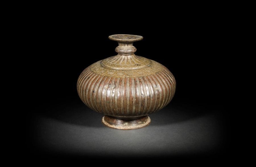 Vase, lota, Inde moghole, XVIIIe siècle
Vase en bronze, à panse lenticulaire, à décor de godrons et d’une frise d’arabesques fleuries à l’épaulement.
H. : 15,5 cm

Vase, lota, Mughal India, 18th century