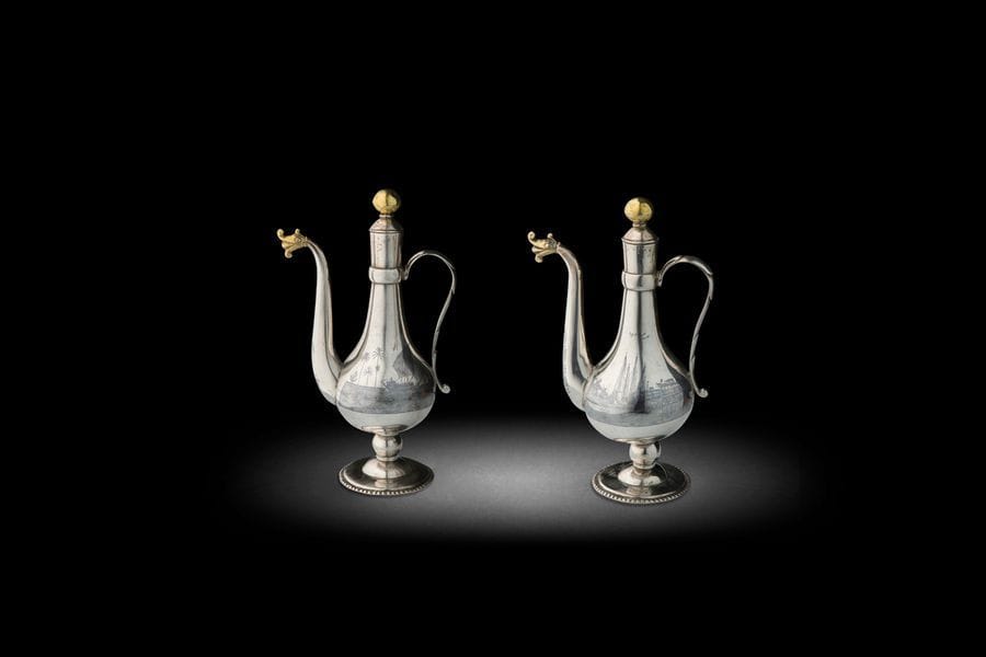 Petite paire de petites aiguières en argent et vermeil, Irak, Bagdad, déb. XXe siècle
Panses piriformes à anse torsadée et déversoir achevé d’une tête de dragon, et col à bouchons sphériques, sur base perlée. Décor niellé de paysage sur l’Euphrate. Signature sur l’une : Mohamad [ ? ]’Aboud
H. : 20 cm ; PB : 526 g

A pair of parcel gilt silver ewers, Iraq, Baghdad, 20th century