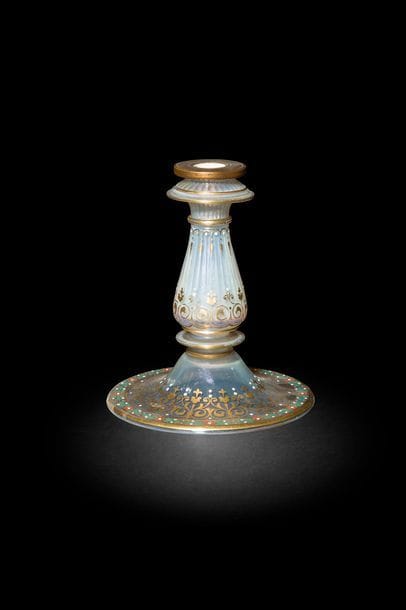 J&J Lobmeyer, bougeoir en verre à fleurons dorés, Autriche, fin XIXe siècle
Fut cannelé à ressaut sur large base et bobèche cerclée en bronze. Décor répétitif d’arabesques fleuronnées. Sur le pourtour de la base, frise de hou émaillée vert et rouge.
H. : 14,5 cm

A J&J Lobmeyr enamelled and gilt glass candlestick, Austria, late 19th century