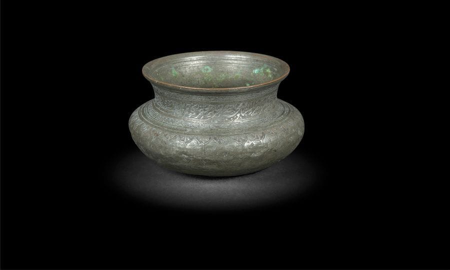 Petit bassin en cuivre étamé, Inde du Nord, fin XIXe siècle
Bassin à panse bombée et col évasé à décor de fleurons et d’une frise inscrite au col des noms des douze Imams shiites.
D. ouveture : 10,5cm

A small tinned-brass basin, North India, late 19th century
