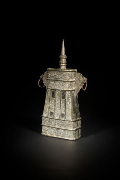 Deux grandes boîtes à poudre, Afrique du nord, XIXe siècle
Chaque boîte est composée d’un corps tronconique à oreilles en khema, laiton et métal argenté, bouchon en forme de minaret. Elles sont décorées en application sur les deux faces, comme sur les côtés bombés et sur les oreilles de plaques de cuivre argentées, découpées, ornées de rinceaux floraux curvilignes, gravés et repoussés.
H. : 49 cm

Two large powder flasks, North Africa, probably Algeria, 19th century