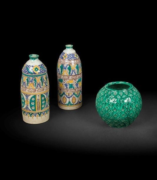 Paire de vases et vase boule, Maroc, Fez, premier tiers du XXe siècle
Faïence à décor en registres de motifs géométriques polychromes séparés par des petites frises violines. À l’épaulement, grains de grenade bleues et motifs cruciformes jaunes ; vase boule à glaçure verte estampé de motifs cruciformes et rosettes sur la panse. Quelques éclats sur le col.
H. : 29 et 17 cm

A pair of vases and a spherical vase, Morocco, Fes, first third 20th century