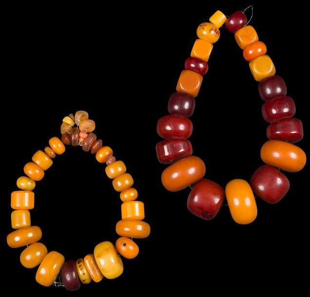 Deux colliers de perles, loubanne, en résine et en ambre, Maroc Anti Atlas occidental, Tiznit
L’un formé d’une enfilade de 20 perles de différentes tailles et couleurs, l’autre, plus petit, de 27 perles de couleur jaune, augmentées de 7 perles en ambre.
D. fermés : 21 et 17 cm

Two pearl and amber necklaces, Loubanna, Morocco, Western Anti Atlas, Tiznit