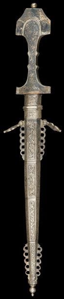 Lot de deux poignards, genoui et koumiyya, Maroc, XXe siècle
- Genoui marocain à lame droite en acier, à poignée et fourreau en argent, à décor repoussé de rinceaux végétaux compartimentés. Anneaux de suspension et appendices latéraux ajourés sur le fourreau ; - Koumiyya à lame courbe en acier, présentant sur une face une inscription gravée sous la garde en argent ciselé. Poignée en bois noirci plaquée dans la partie supérieure d’une feuille d’argent à décor ciselé. Fourreau en argent ciselé d’un décor de rinceaux végétaux, palmettes et rosettes et flanqué de deux anneaux de suspension.
L. : 41,5 cm ; long. : 40,5cm ; PB : 1588 g
État : lame rouillée pour le premier et traces de coup dans le bois, lame usée.

Two daggers, a genoui and a koumiyya, Marocco, 20th century