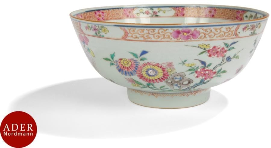CHINE - XVIIIe siècle
Grand bol en porcelaine à décor émaillé polychrome de la famille rose de fleurs de lotus, chrysanthèmes, iris et prunus dans leur feuillage parmi les rochers. 
Diam. : 23,3 cm (usure des émaux).