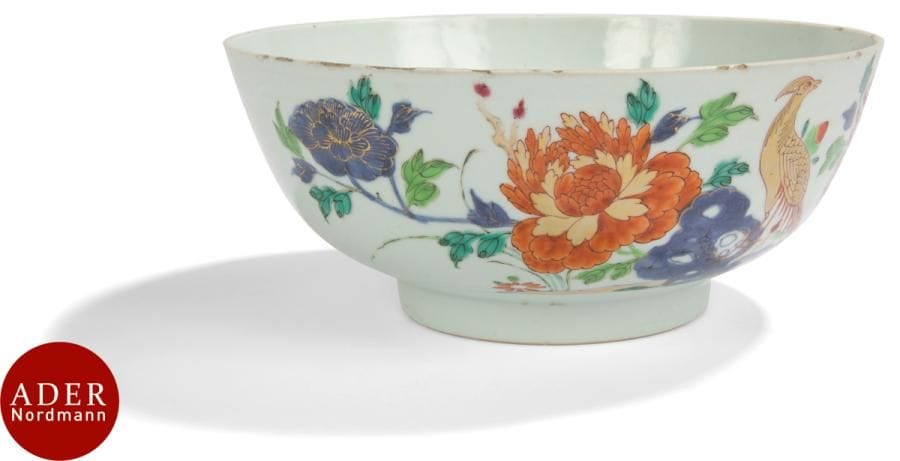 CHINE - XVIIIe siècle
Grand bol en porcelaine à décor émaillé polychrome de la famille rose et or de phénix perché sur le rocher parmi des branches de fleurs de lotus en fleurs et de bourgeons. 
Diam. : 23,7 cm (égrenures).