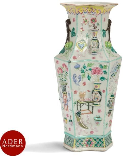 CHINE - XIXe siècle
Vase balustre à pans coupés en porcelaine émaillée polychrome à décor moulé en relief d’objets mobiliers et branches de kaki. 
H : 39,8 cm