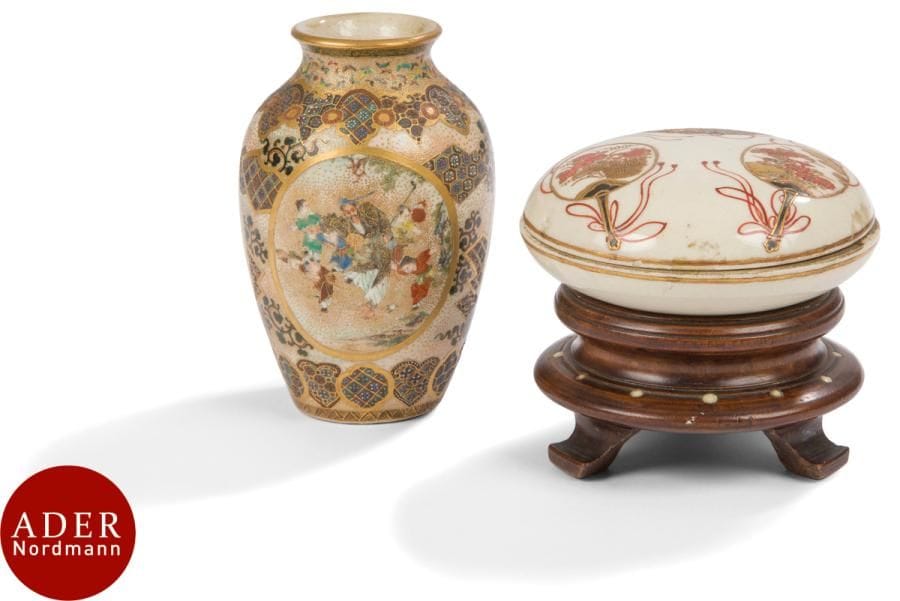 JAPON, Fours de Satsuma - XXe siècle
Un petit vase balustre et une boîte ronde en faïence de Satsuma émaillée polychrome et or, à décor d’un homme et d’enfant dans des médaillons sur fond de motifs géométriques et kiku, ornée d’éventails.
H : 9, 5 cm ; diam. boîte : 8 cm. Socle en bois.