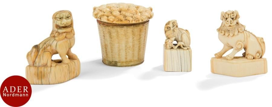 JAPON - Époque MEIJI (1868 - 1912)
Ensemble en ivoire comprenant trois okimono dans le style des netsuke formant shi shi sur un socle et un panier couvert. 
H : de 3,9 à 4,9 cm (accident et manque).