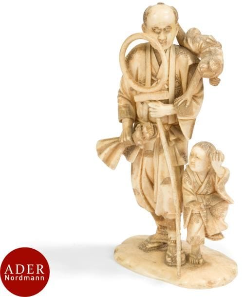 JAPON - Époque MEIJI (1868 - 1912)
Okimono en ivoire sculpté, dresseur de singe avec une guenon sur l’épaule, un enfant à ses pieds lui tendant un fruit. 
H : 19,5 cm (manque un élément dans la main du singe).