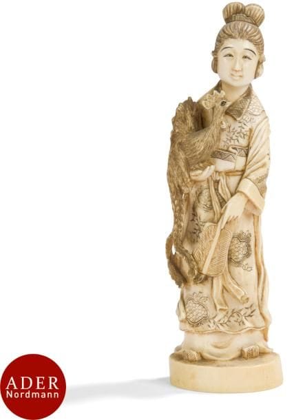 JAPON - Époque MEIJI (1868 - 1912)
Okimono en ivoire, jeune femme debout tenant un éventail dans la main gauche, un coq dans la main droite. 
H : 18,5 cm