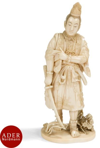 JAPON - Époque MEIJI (1868 - 1912)
Okimono en ivoire sculpté, samouraï debout tenant son sabre de la main droite, en relevant la manche de celle-ci de sa main gauche, des fleurs à ses pieds. Signé Kunigetsu.
H : 21 cm (petits manques aux fleurs et tiges).