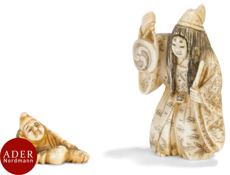 JAPON - Époque MEIJI (1868 - 1912)
Deux netsuke en ivoire, chaman debout tenant un tambour de la main gauche, pêcheur assis et son poisson. 
H : de 3,9 à 6,5 cm