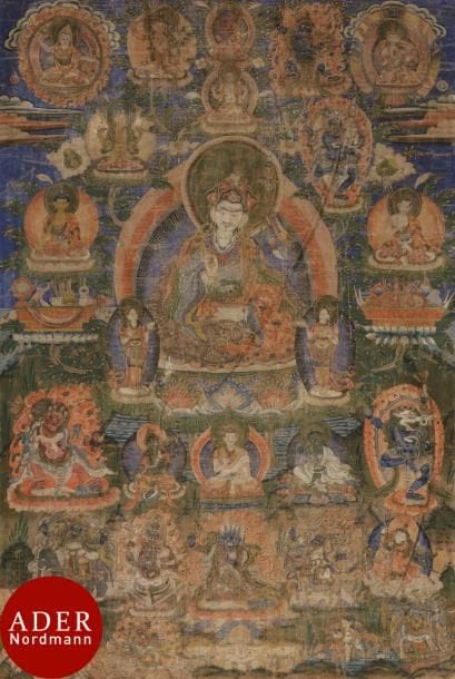 TIBET - XIXe siècle
Tangka, détrempe sur toile. Padmasambhava au centre sur fond bleu, assis sur le lotus, tenant un vajra dans la main droite, le kapala contenant le vase d’immortalité dans la main gauche, le Khatvanga trishula reposant entre son bras et son épaule gauche ; entouré de divinités en furie, lamas et bouddha. (Usures).
Dim. : 74 x 50 cm