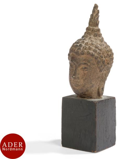 THAILANDE - XVIIe/XVIIIe siècle
Petite tête de bouddha en bronze à patine brune le haut du chignon formant l’ushnisha. 
H : 7,5 cm