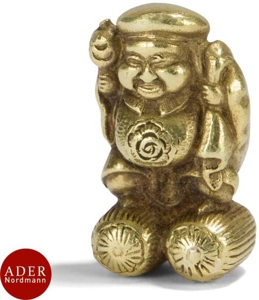 JAPON - Époque MEIJI (1868 - 1912)
Daikoku en or (750/1000), debout sur deux bottes de riz, tenant son maillet.
H. : 2 cm ; Poids : 13,5 g