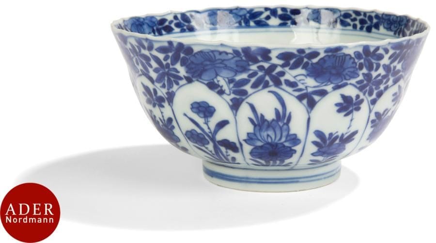 CHINE - XVIIIe siècle
Bol polylobé en porcelaine émaillée en bleu sous couverte  de frise de fleurs dans leur feuillage, la panse formant des pétales de lotus. Marque apocryphe chenghua. 
Diam. : 14,8 cm (égrenures).