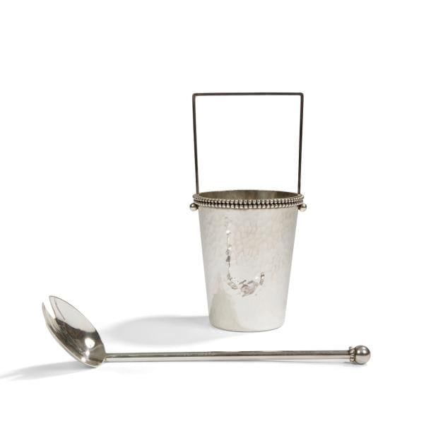 JEAN DESPRÉS (1889-1980)

Seau à glace et sa cuillère.
Épreuves en métal argenté.
Le seau tronconique à surface martelé reçoit une anse, traitée lisse et en U renversé, deux sphères simulant les fixations de la prise et un double rang perlé en motif décoratif.
La cuillère, au cuilleron à trois dents, présente un manche cylindrique sommé d’une sphère reposant sur une frise perlée.
Le seau signé et daté J. DESPRÉS 16.(0)9.(19)67, à la pointe sous la base. 
Hauteur du seau : 21 cm
Longueur de la cuillère : 26 cm

Provenance :
Ancienne Collection M. et Mme L. à Saint-Léger-Vauban, anciens commerçants avallonais. Œuvre acquise par ces derniers directement auprès de l’artiste.
