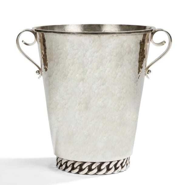 JEAN DESPRÉS (1889-1980)

Important seau à champagne moderniste en métal argenté.
Le corps à surface martelée reçoit deux prises en volutes fixées par des sphères traitées lisses et accueille une épaisse gourmette à maillons plats en pourtour de sa base en retrait.
Le col est souligné, sur l’extérieur, d’un jonc en ressaut.
Signé J. DESPRÉS, à la pointe sous la base.
Hauteur : 25 cm

Provenance :
Ancienne Collection M. et Mme L. à Saint-Léger-Vauban, anciens commerçants avallonais. Œuvre acquise par ces derniers directement auprès de l’artiste.