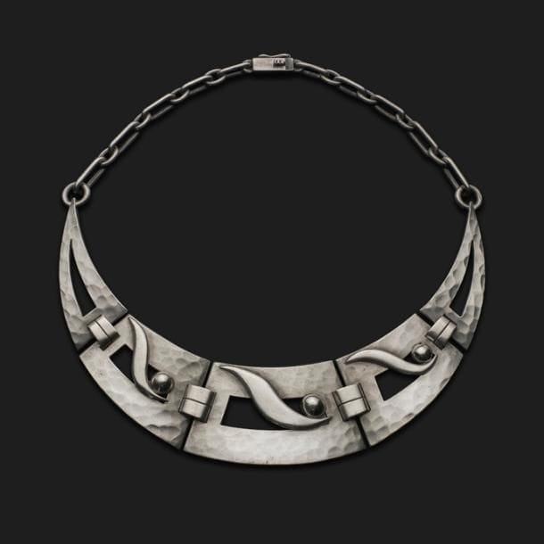 JEAN DESPRÉS (1889-1980)

Très rare collier tour de cou moderniste en argent.
Les cinq larges plaques articulées et formant un croissant de Lune sont aux motifs de sphères et de formes libres en application sur des fonds ajourés et largement martelés.
Les chaînes latérales sont constituées de maillons de longueurs et d’épaisseurs allant en dégressivité jusqu’au fermoir.
Signé J. DESPRÉS à la pointe au revers d’une des plaques et porte les poinçons de Maître Orfèvre et de garantie, à deux reprises, sur une des plaques et le fermoir.
Poids : 101,57 g 

Provenance :
Ancienne Collection M. et Mme L. à Saint-Léger-Vauban, anciens commerçants avallonais. Œuvre acquise par ces derniers directement auprès de l’artiste.
