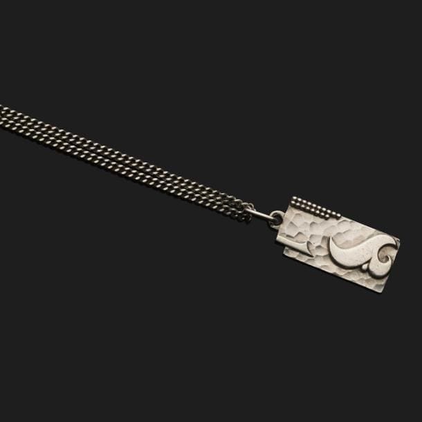 JEAN DESPRÉS (1889-1980)

Pendentif moderniste en argent et sa chaîne.
La plaque rectangulaire, à une échancrure dans son angle supérieur gauche, reçoit un décor en application de formes libre et de rangs perlés sur fond à large martelage.
Signé J. DESPRÉS à la pointe au revers de la plaque et frappé des poinçons de Maître Orfèvre et de garantie sur la bélière et sur le fermoir de la chaîne.
Poids : 49,24 g

Provenance :
Ancienne Collection M. et Mme L. à Saint-Léger-Vauban, anciens commerçants avallonais. Œuvre acquise par ces derniers directement auprès de l’artiste.