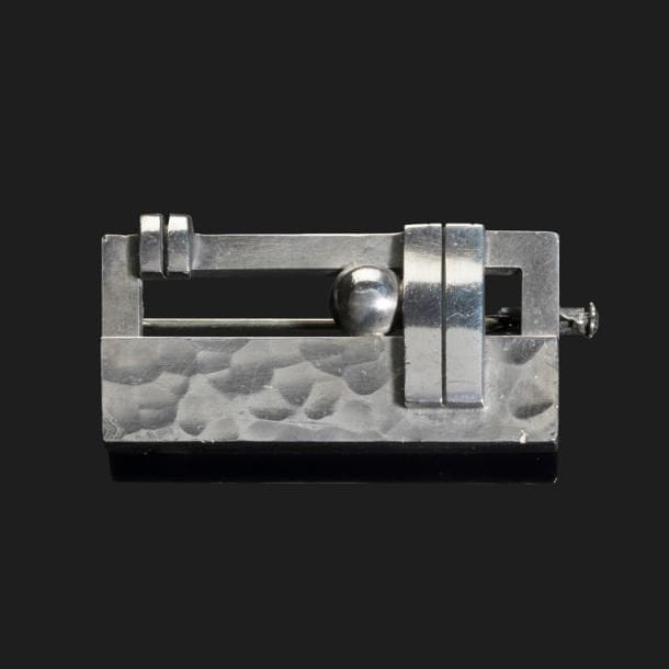 JEAN DESPRÉS (1889-1980)

Rare broche moderniste en argent.
La plaque rectangulaire ajourée est, pour partie, martelée et reçoit des motifs décoratifs d’agrafes et d’une sphère en application.
Frappée des poinçons de Maître Orfèvre et de garantie au revers.
Poids : 18,91 g