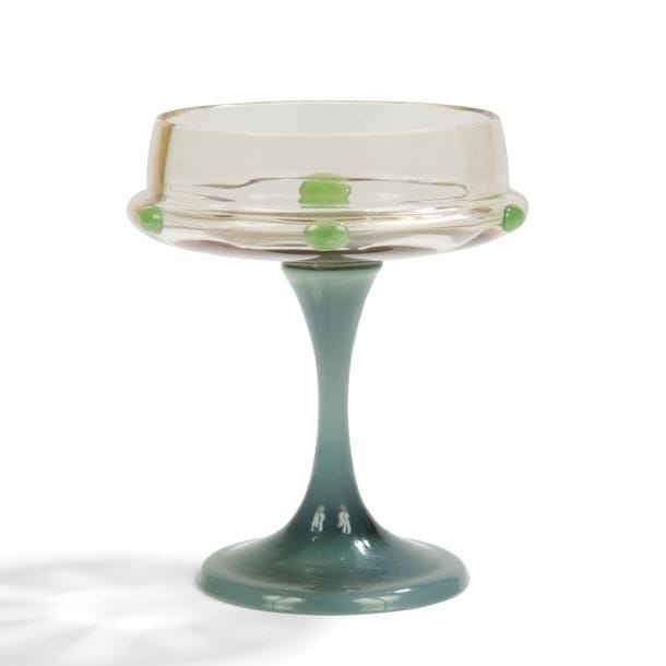 ÉMILE GALLÉ (1846-1904)

Verre à pied.
La jambe en verre à l’évocation de l’agate.
La coupe en verre fumé ornée de cabochons en verre modelés et collés à chaud évoquant le jade.
Une infime égrenure (tête d’épingle) en bordure.
Hauteur : 12 cm

Bibliographie :
The Paris Salons 1895-1914- Volume IV : Céramics & Glass - Alastair Duncan, Antique Collectors’ Club, 1998. Modèle identique reproduit page 235.