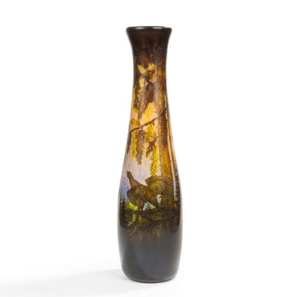 DéSIRÉ MULLER (1877-1952) À LUNÉVILLE

Grand Tétras en Vosges, pièce unique réalisée pour un parent de l’artiste lors d’un événement d’ordre familial
Exceptionnel et spectaculaire vase ; le corps en massue piriforme au col terminé évasé.
Épreuve en verre multicouche au décor tournant dégagé à l’acide ; les arbres conifères du premier plan traités vert et dans des nuances de brun, le volatile, la forêt et le lac traités brun-noir sur un fond marmoréen jaune orangé mêlé de bleu.
Le décor repris, en grand partie, en gravure à la roue.
Signé et situé MULLER Lunéville France, gravé en lettres bâtons vers la base. 
Hauteur : 76 cm

Provenance :
Descendance directe de l’artiste.

Important :
Concepteur de l’œuvre, Désiré Muller a très probablement, selon la tradition orale familiale, exécuté lui-même, probablement vers 1929 / 30, le décor à l’acide et son achèvement à la roue.

Bibliographie :
Les frères Muller, maîtres verriers à Lunéville – Benoît Tallot, édition Serpenoise, Metz, 2008. Œuvre référencée et reproduite page 83 (avec une coquille dans la datation).
