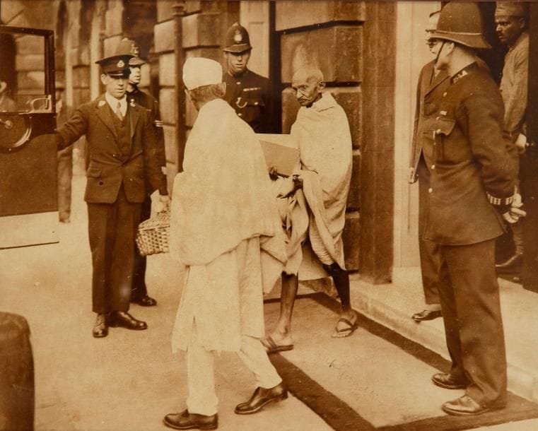 *Mohandas Karamchand GANDHI (1869-1948) Photographie avec signature autographe « MK Gandhi » ; 18,4 x 23 cm à vue (encadrée, encre un peu pâle)
Photographie de presse originale, avec le cachet au dos de Planet News Ltd Elle représente Gandhi quittant le palais de Saint-James où il avait assisté à la deuxième Round Table Conference à propos des réformes constitutionnelles en Inde (7 septembre-1er décembre 1931), sous l’œil des policiers ; Gandhi a signé sur le paillasson sur lequel il marche

5.5% de frais additionnels au titre de la taxe à l’importation temporaire 