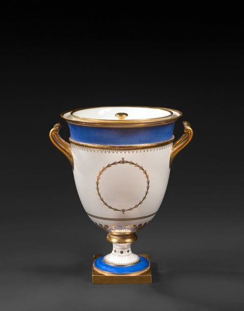 Sèvres
Vase glacière AB couverte en porcelaine garnie de sa doublure à décor en or de médaillon, guirlandes de feuillage et rosaces, les bords à fond bleu, la base carrée à fond or.
Époque Restauration.
H. : 32 cm