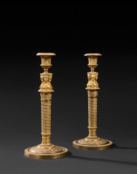 Paire de grands flambeaux en bronze doré, le fût à frises de ruban torse ornées de feuillages, surmonté de trois bustes de vestales et reposant sur une base circulaire à feuilles d’érable et rosaces.
Époque Empire.
H : 33,5 cm