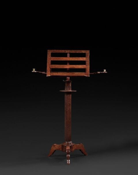Pupitre à musique en acajou, le fût cannelé à piétement tripode surmonté d’un double pupitre à bras de lumière articulés.
Vers 1830.
H : 133 cm, L : 50 cm