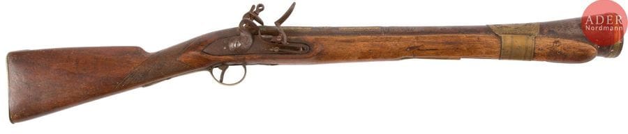 Fort et long tromblon à silex.
Canon rond à pans au tonnerre entièrement gravé, ciselé et décoré d’incrustations de cuivre. Platine et chien col de cygne européens, à corps ronds gravés. Garnitures en bronze ciselé. Crosse en noyer en partie quadrillé.
E.M. Balkans XIXe siècle (manque la baguette). 
Longueur totale : 90 cm