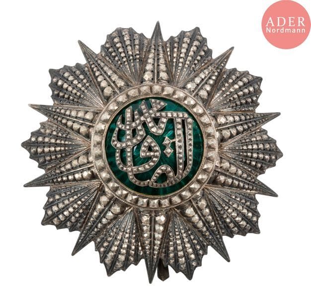TUNISIE - ORDRE DU NICHAN IFTIKHAR
Plaque de grand-croix au monogramme de Mohammed-es-Sadok (1859-1882).
En argent travaillé à pointes de diamant et émail (éclats), repercés. Revers à attache basculante et deux crochets.
Poinçons tête de sanglier et marque du fabriquant Haley aux grandes armes impériales.
Diamètre : 8,1 cm - Poids brut : 80,5 g
