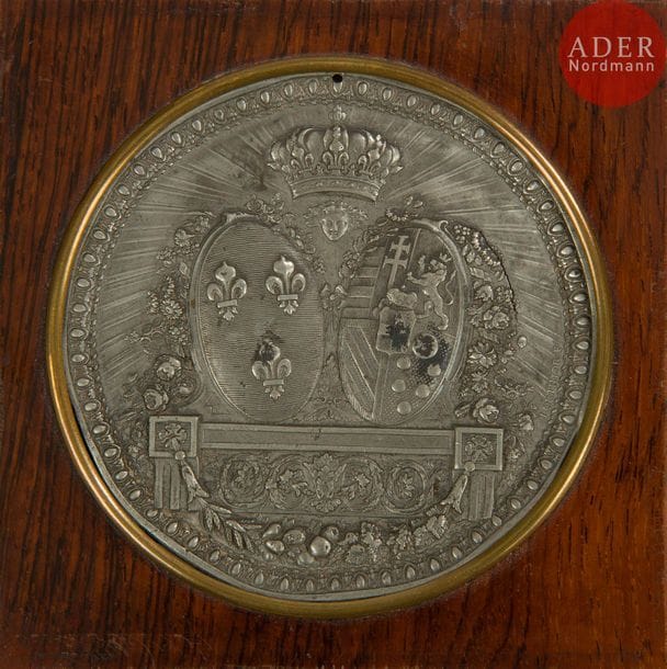 LORTHIOR (d’après)
Armes d’alliance du Roi Louis XVI et de la Reine Marie Antoinette
Médaillon estampé en étain. 
Diamètre : 7,5 cm 
Dans un cadre en bois. 
B.E